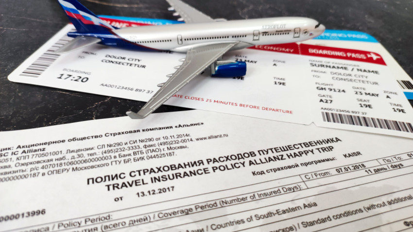 Самолёт Аэрофлота и посадочные талоны рядом со страховым полисом