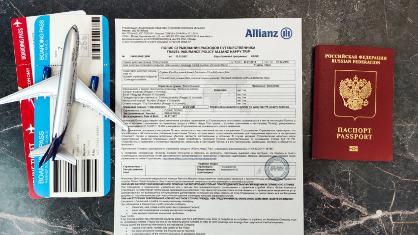 Посадочные талоны, полис Allianz и паспорт на фоне макета самолёта