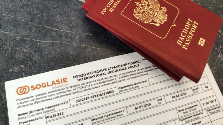 Российский загранпаспорт и страховой полис на столе