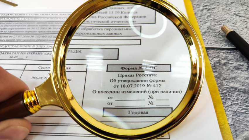Форма 4-ОС под увеличительным стеклом на столе