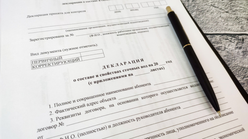 Декларация о составе сточных вод с ручкой на каменной поверхности