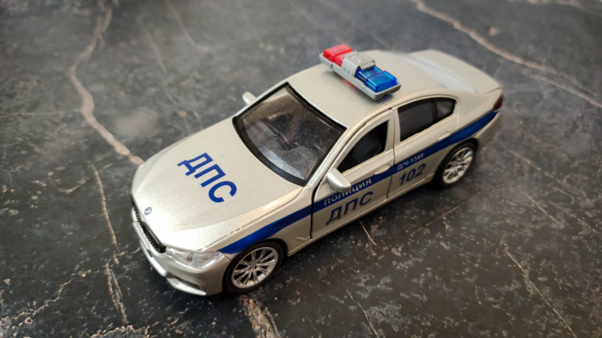 Игрушечная модель патрульного автомобиля на фоне мрамора