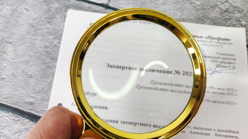 Экспертное заключение под увеличительным стеклом в руке