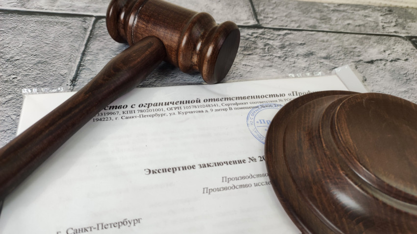Судейский молоток и экспертное заключение на фоне бетонной поверхности