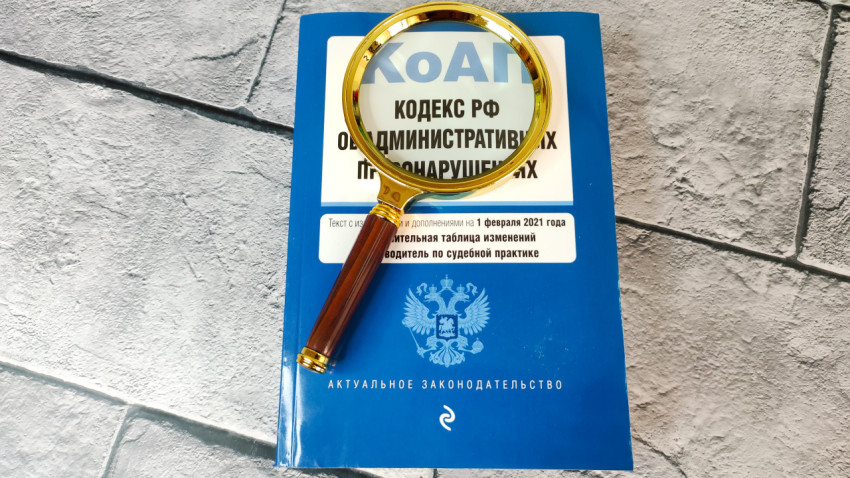 КоАП РФ под лупой на фоне плитки