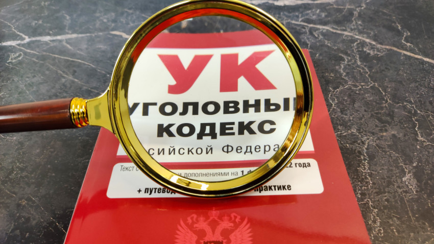 Уголовный кодекс РФ в фокусе увеличительного стекла на столе