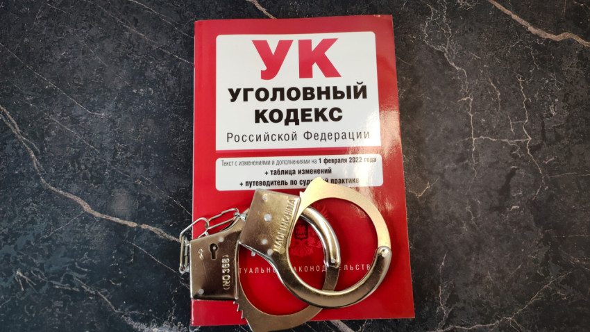 Книга Уголовного кодекса РФ и наручники на мраморной поверхности