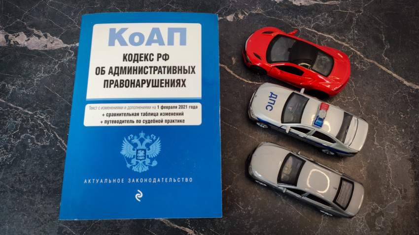 Книга КоАП РФ и три игрушечные машинки