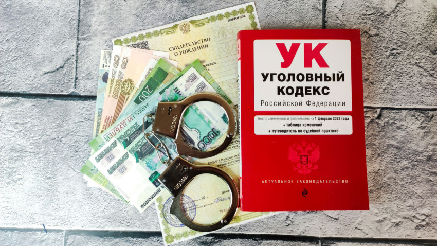 Уголовный кодекс РФ с наручниками, деньгами и документами