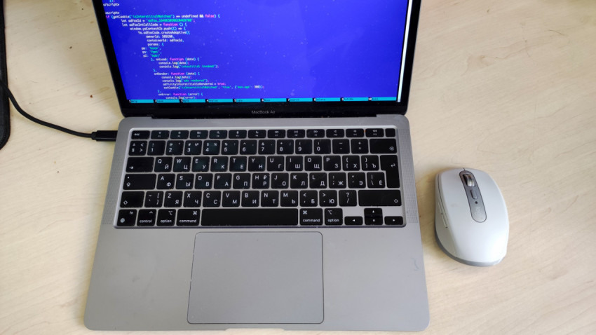 MacBook Air с открытым кодом и беспроводной мышью на столе