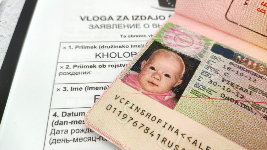 Шенгенская виза в паспорте на фоне анкеты для подачи документов