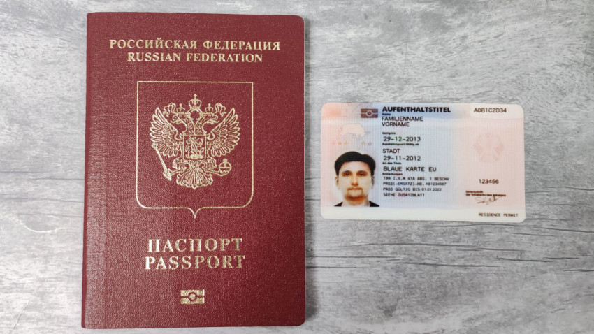 Паспорт РФ и немецкий вид на жительство рядом на столе