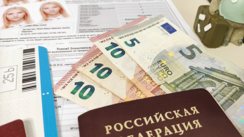 Евро и заграничный паспорт на фоне визовых документов