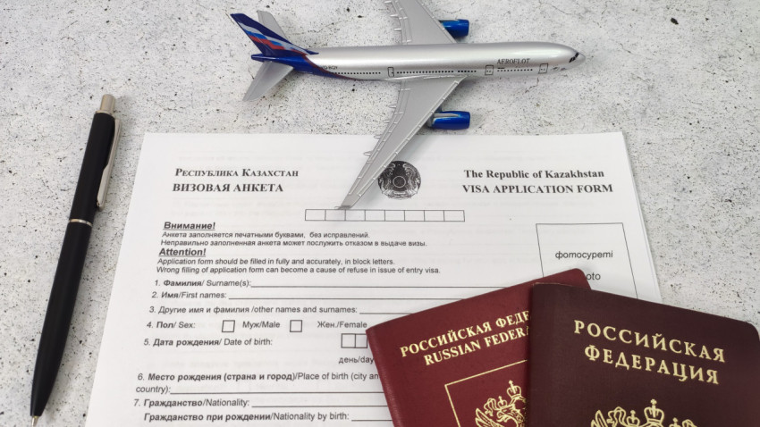 Визовая анкета Казахстана с моделью самолета и паспортами РФ