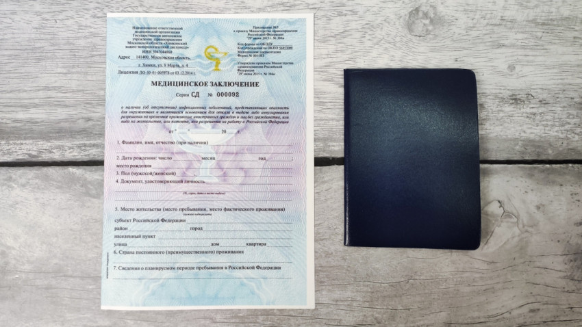 Медицинское заключение и обложка документа на деревянной поверхности