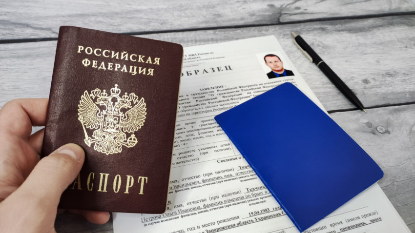 Паспорт России, синий документ и заявление на сером столе