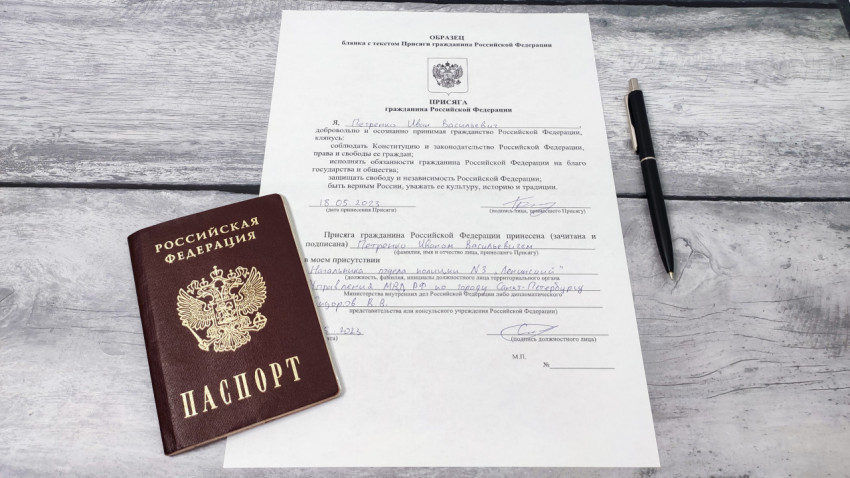Паспорт РФ и заполненный бланк присяги на столе с ручкой