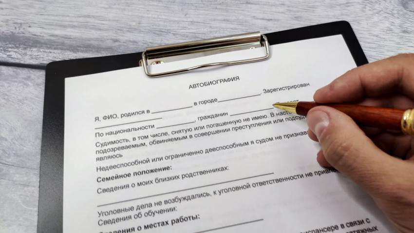 Заполнение автобиографии на бланке с планшетом и ручкой