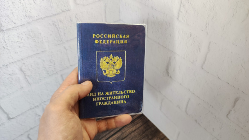 Обложка вида на жительство иностранного гражданина в руке