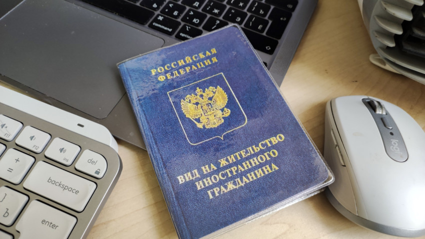 Вид на жительство иностранного гражданина рядом с компьютером