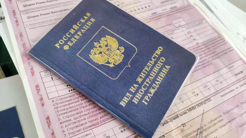 Вид на жительство иностранного гражданина на фоне страхового полиса