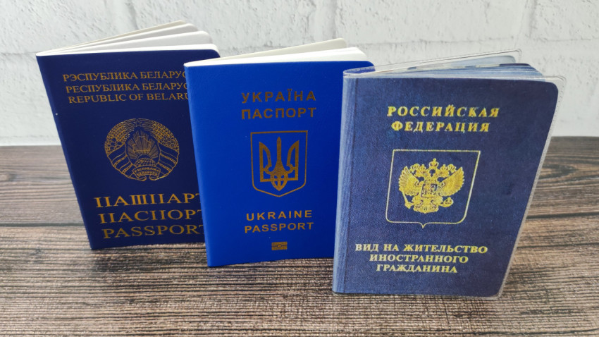 Паспорта Беларуси и Украины и вид на жительство в России на деревянной поверхности