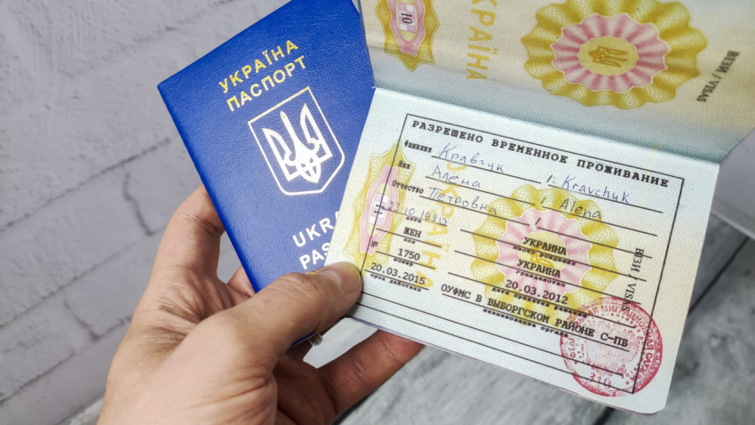 Паспорт Украины с разрешением на временное проживание в руке