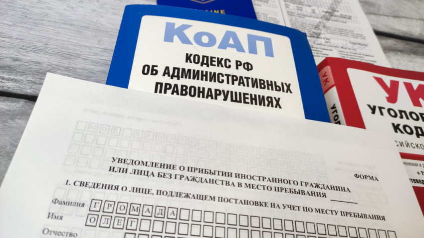 Уведомление о прибытии иностранного гражданина с кодексами РФ на столе