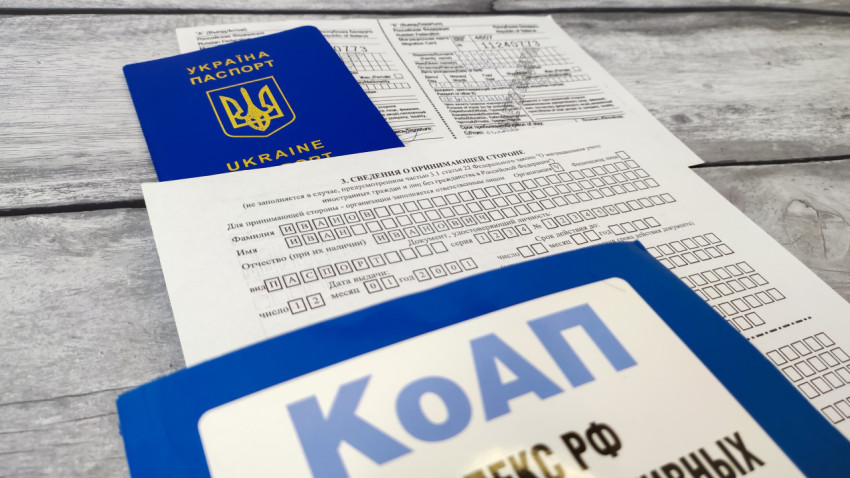 Паспорт Украины и бланк уведомления о прибытии с кодексом РФ на переднем плане
