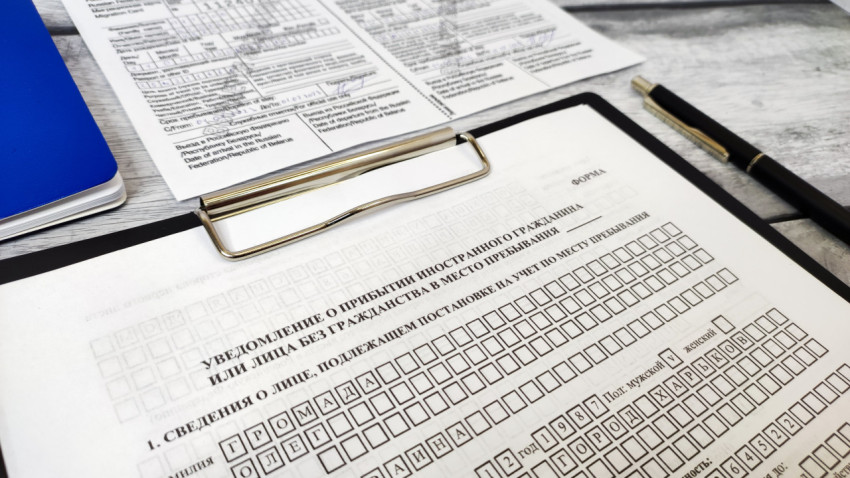 Уведомление о прибытии с паспортом Украины и ручкой на фоне миграционной карты