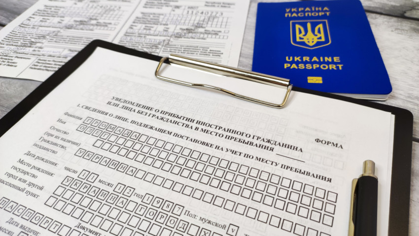 Паспорт Украины и уведомление о прибытии на фоне миграционной карты