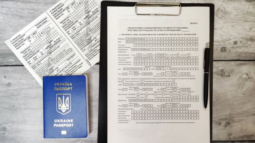 Паспорт Украины и уведомление о прибытии с миграционной картой на столе