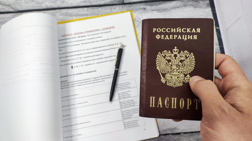 Паспорт Российской Федерации на фоне теста по русскому языку
