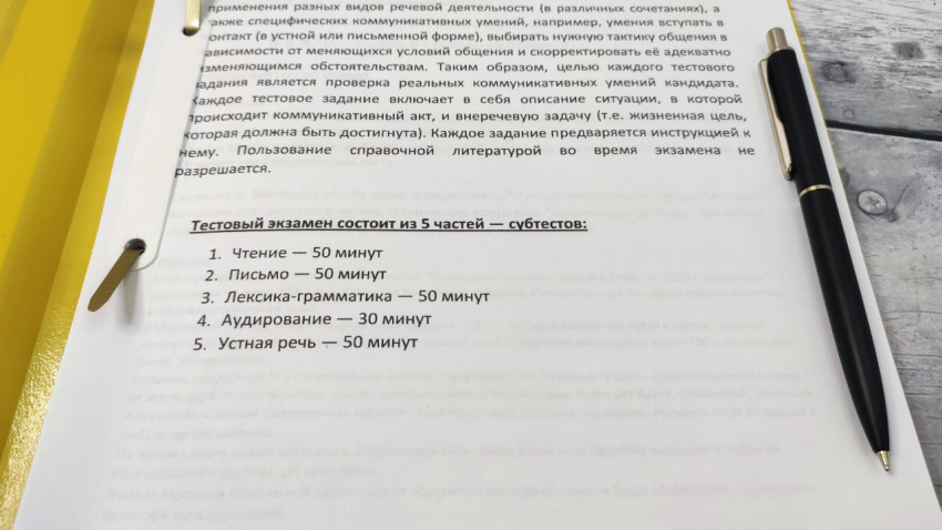 Страница с перечнем частей тестового экзамена и ручкой