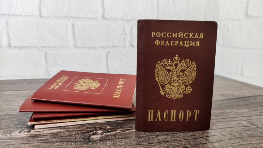 Внутренний российский паспорт на фоне стопки загранпаспортов