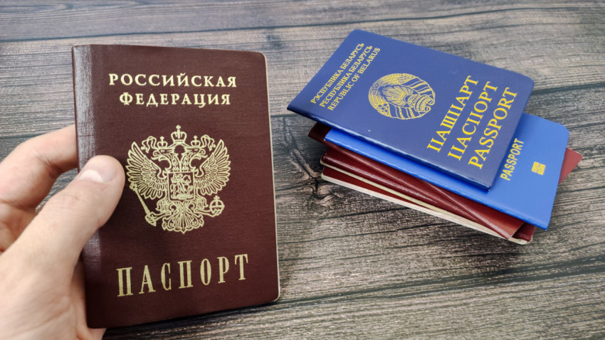Российский паспорт и белорусский паспорт в стопке на деревянном столе