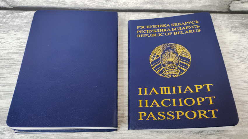 Паспорт Республики Беларусь и синий документ на деревянной поверхности