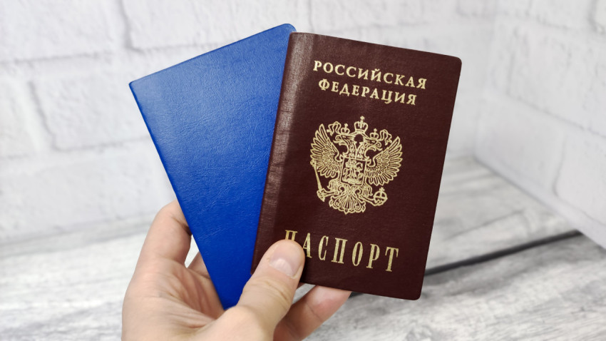 Паспорт России и синий документ в руке
