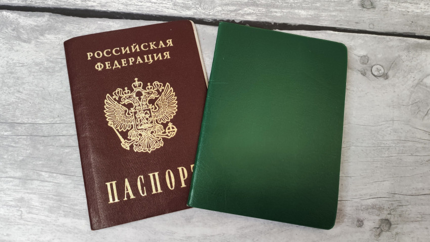 Паспорт России и зелёный документ на серой деревянной поверхности