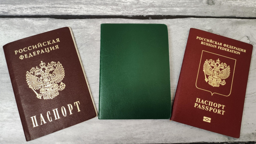 Внутренний и заграничный паспорта России с зеленым документом на столе