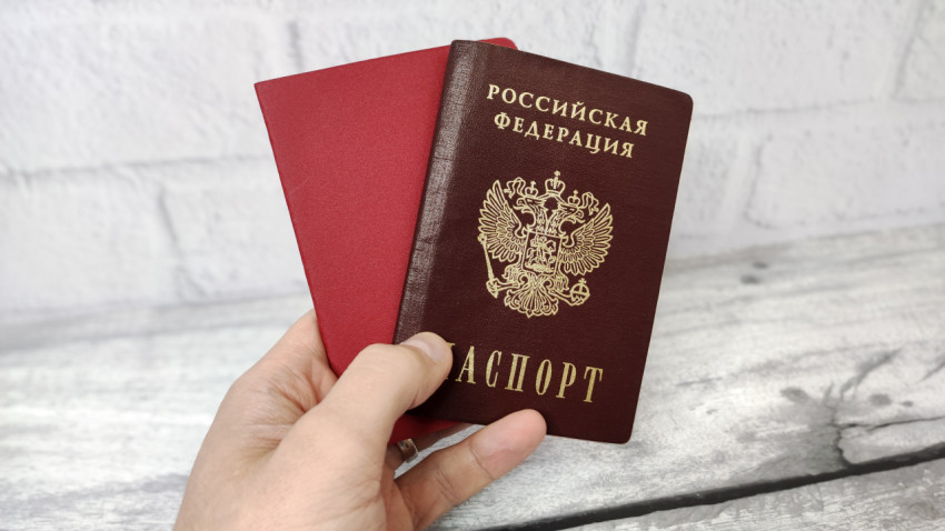 Паспорт гражданина России в руке с красным документом