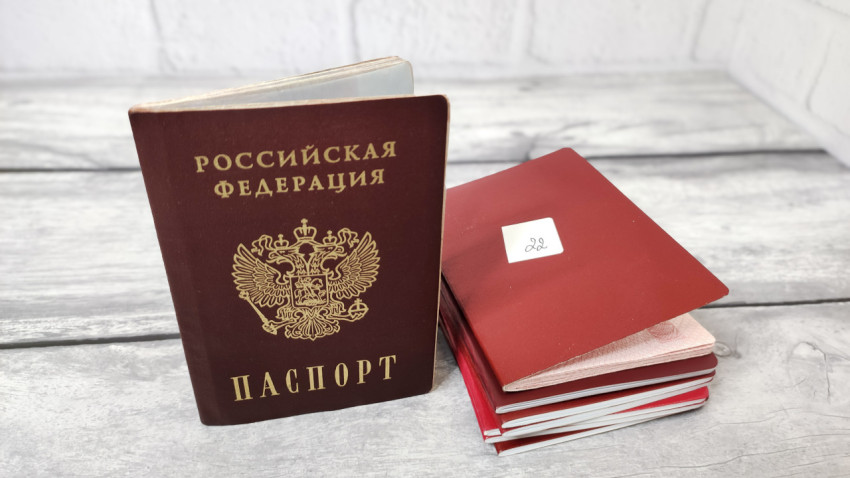 Паспорт РФ и стопка красных обложек с маркировкой