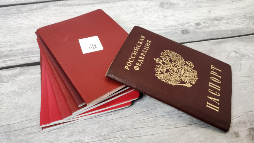 Паспорт РФ и стопка документов в красных обложках