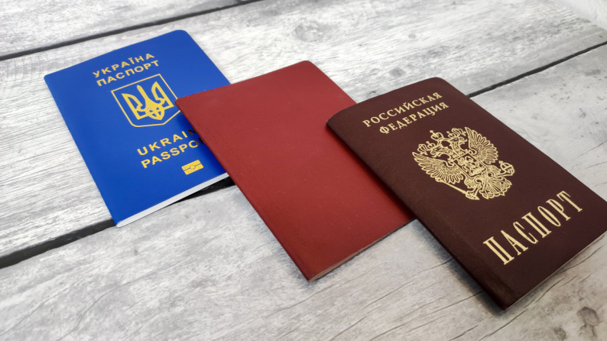 Паспорта России и Украины с красной обложкой на столе