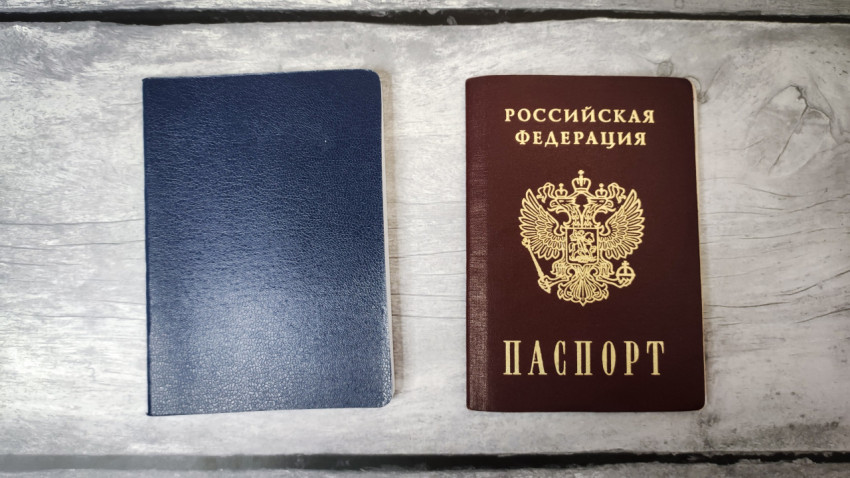 Паспорт России и тёмно-синяя обложка на деревянной поверхности