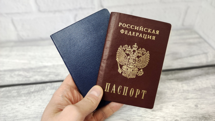 Паспорт России и синяя обложка в руке