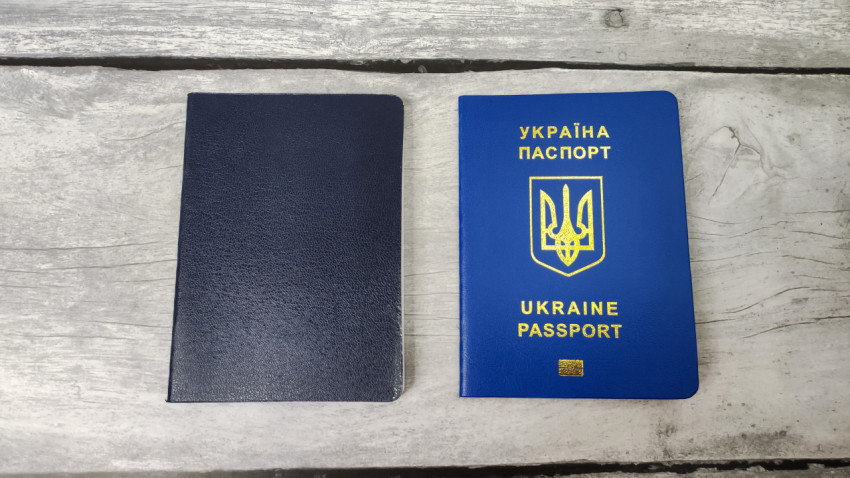Паспорт Украины и синий документ на деревянной поверхности