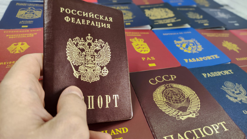 Паспорт Российской Федерации в руке на фоне паспортов других стран