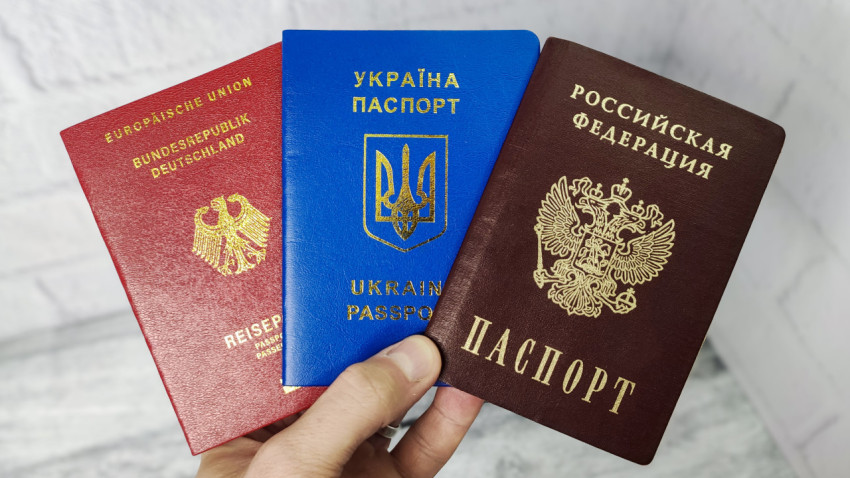 Паспорта Германии, Украины и России в руке
