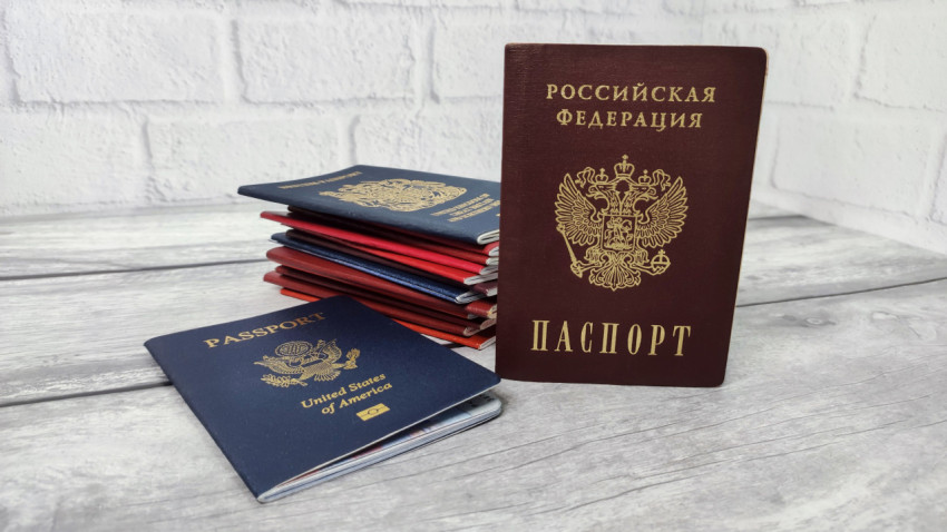Паспорт России на фоне стопки иностранных паспортов